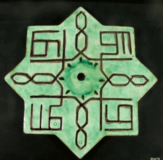 Eight-pointed Kutahya star tile in green polychrome ceramic with incised kufic ornament